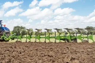 Traktor s pluhem Amazone při orbě na poli