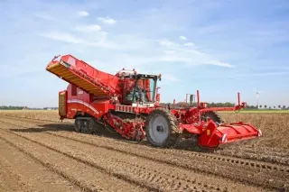 Červený samojízdný sklízeč brambor Grimme Varitron 470 na poli.