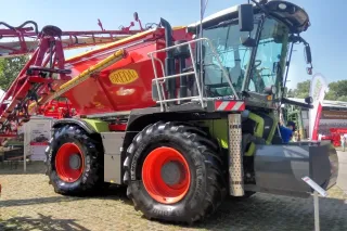 Traktor Claas Xerion s červeným rozmetadlem Bredal na výstavě