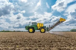 Postřikovač John Deere při práci na poli
