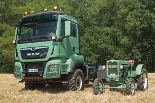 Zelený zemědělský nákladní automobil MAN vedle historického traktoru
