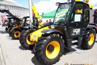 Dva žlutočerné manipulátory JCB na výstavě