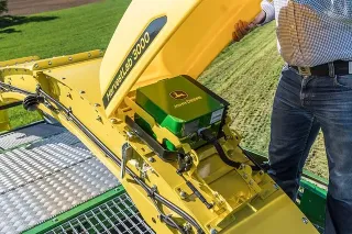 Detail žlutého ústrojí sklízecí řezačky John Deere