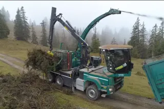 Mobilní štěpkovač Jenz Cobra zpracovává větve a fouká štěpku do přívěsu.