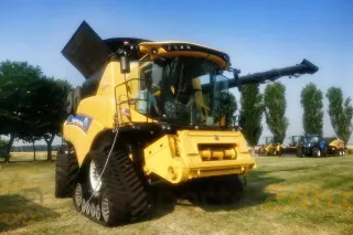 Žlutá sklízecí mlátička New Holland s pásovým podvozkem