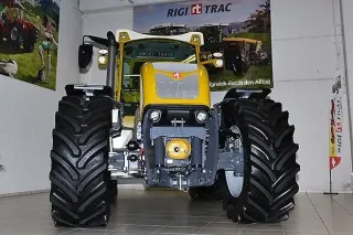 Čelní pohled na žlutý traktor Rigitrac ve výstavní hale