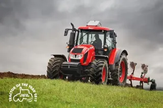 Červený traktor Zetor Forterra HD s pluhem na poli