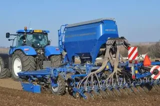 Modrý traktor se secím strojem Köckerling Vitu 600 na poli