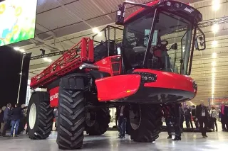 Červený samojízdný postřikovač Agrifac Condor Endurance vystavený v hale.