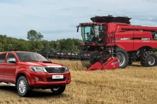 Červený pick-up Toyota a sklízecí mlátička Case IH