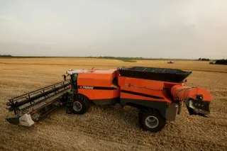 Oranžový kloubový kombajn Tribine na poli