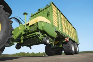 Zelený senážní vůz Krone připojený za traktor