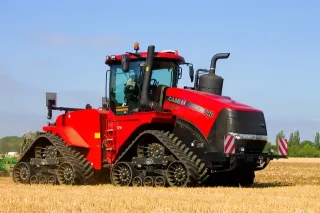 Červený pásový traktor Case IH na poli
