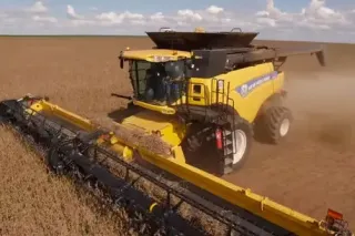 Žlutá sklízecí mlátička New Holland při sklizni sóji