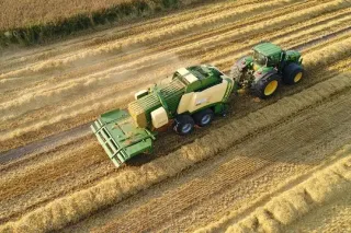 Traktor John Deere s lisem Krone při sklizni slámy