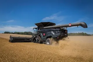 Černá sklízecí mlátička Massey Ferguson IDEAL při sklizni obilí