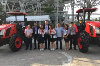Skupina lidí mezi traktory Zetor ve Vietnamu