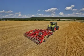 Červený kultivátor Horsch Terrano GX za traktorem na poli