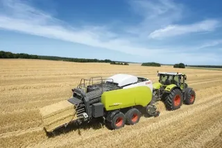 Traktor Claas s lisem na hranolové balíky na poli