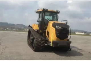 Žlutý pásový traktor Challenger na betonové ploše