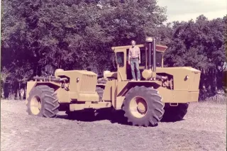 Historický žlutý traktor Big Jack s mužem na plošině