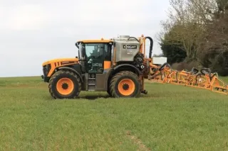 Traktor JCB Fastrac s postřikovací nástavbou a rozloženými rameny