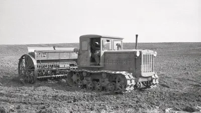 Archivní černobílý snímek pásového traktoru DT-54 se secím strojem