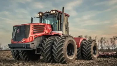 Červený kloubový traktor Kirovets na poli