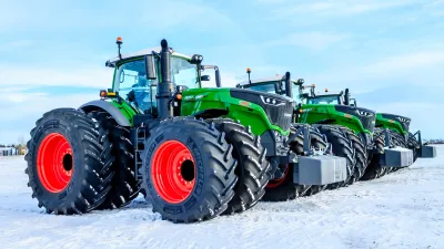 Řada velkých zelených traktorů Fendt na sněhu