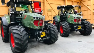 Dva zelené traktory Hürlimann ve výstavní hale