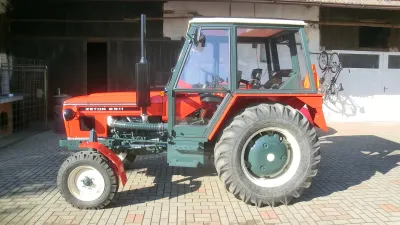 Zrenovovaný červený traktor Zetor 6911 na dvoře
