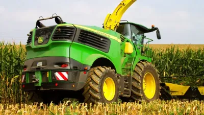 Zelená řezačka John Deere při sklizni kukuřice