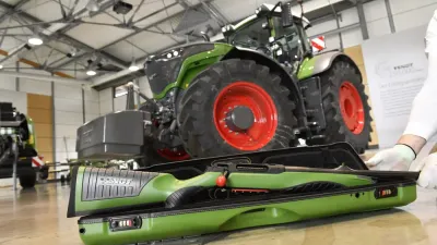 Lovecká puška v popředí a traktor Fendt v hale