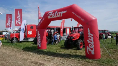 Traktor Zetor pod červeným reklamním obloukem na výstavě