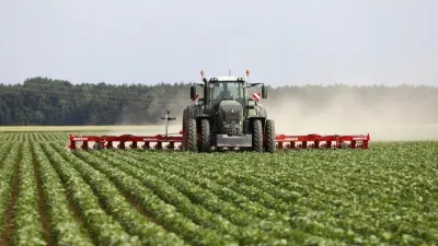Traktor s červeným kultivátorem Horsch na poli