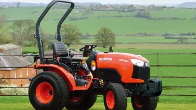 Oranžový malotraktor Kubota na louce
