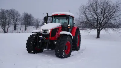 Červený traktor Zetor na zasněženém poli