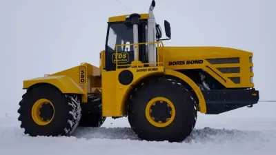 Žlutý historický traktor Kirovets na bílém pozadí