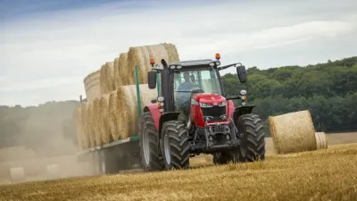 Traktor Massey Ferguson s nákladem balíků slámy