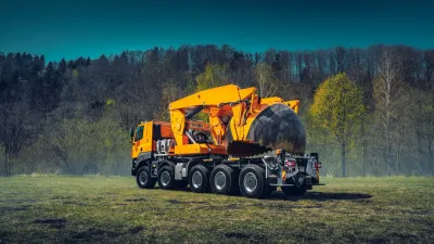 Oranžová Tatra Phoenix s přesazovačem stromů na louce