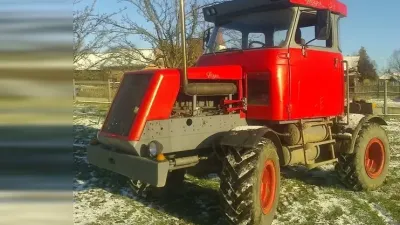 Doma postavený červený traktor z dílů nákladních vozidel