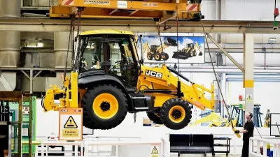 Žlutý stroj JCB ve výrobní hale