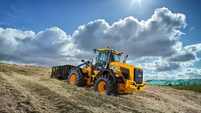 Žlutý kolový nakladač JCB u silážní jámy