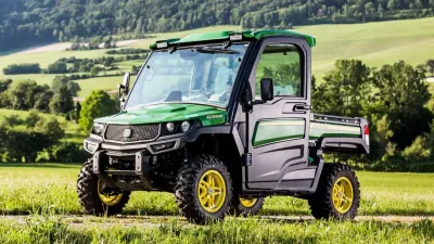 Zelené užitkové vozidlo John Deere Gator v krajině