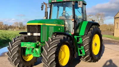Zelený traktor John Deere 7810 na louce