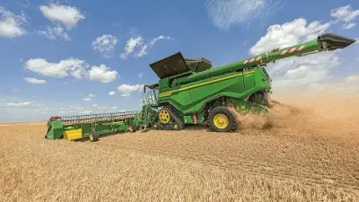 Zelená sklízecí mlátička John Deere na poli