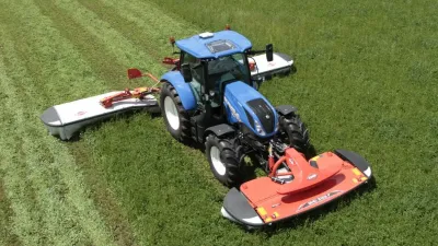 Modrý traktor se žacím strojem Kuhn na louce