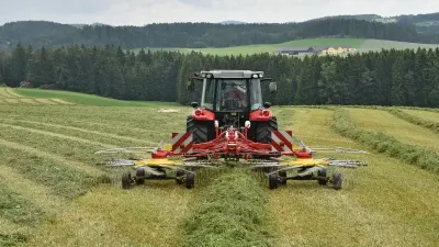 Traktor se žacím strojem na posečené louce