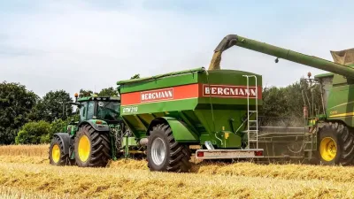 Zelený překládací vůz Bergmann GTW 210 za traktorem