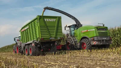 Řezačka plní zelený vůz Fendt senáží